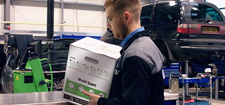Person, die in einer Werstatt arbitet und eine Mobil Boxx in der Hand hält