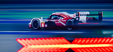 Roter und weißer Porsche-Rennwagen auf einer Rennstrecke