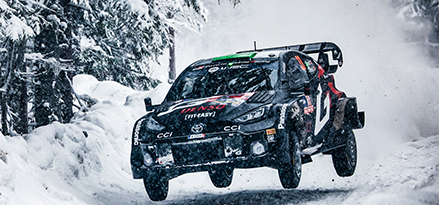 Toyota-Rennwagen fährt durch Schnee in der Luft.