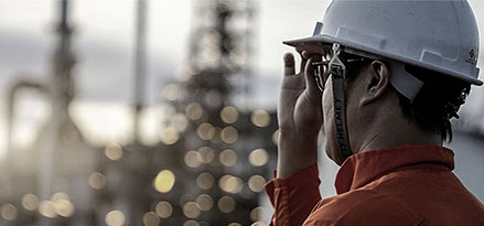 Mitarbeiter von Mobil mit Blick auf ein großes Werk