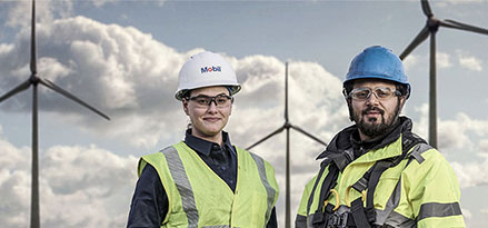 Mitarbeiter und Kunde von Mobil vor einem Windpark