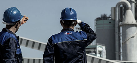 Kunde und Mitarbeiter von Mobil mit Blick auf ein großes Werk